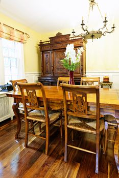 Dining room interior with antique wooden table and chairs in house