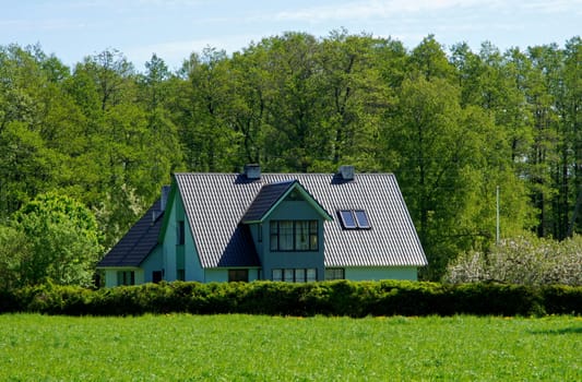 The modern house on a background of green trees
