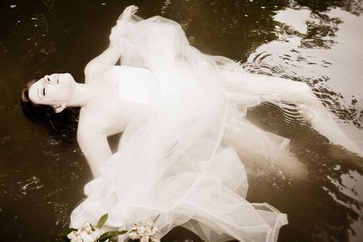 A bride floating in the water, asleep or dead