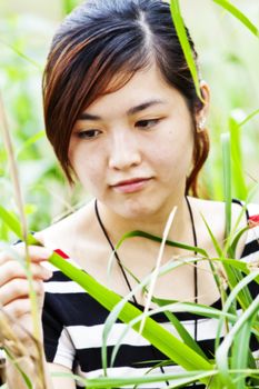 Asian woman in nature with grasses