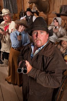 Heavyset gunslinger with shotgun in crowded old western saloon