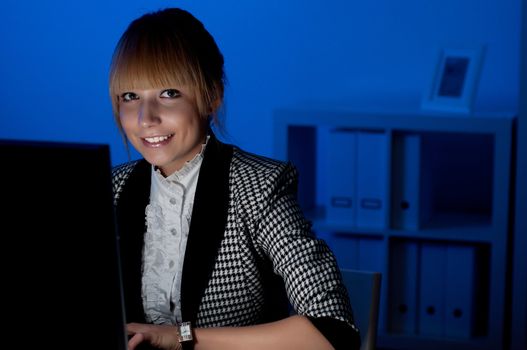 beautiful young business woman working at night in the office