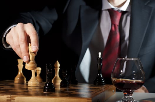 image of the businessman in a business suit plays chess