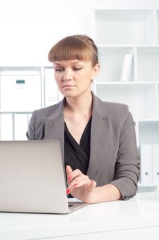 portrait of a beautiful young woman who works at a laptop in the office