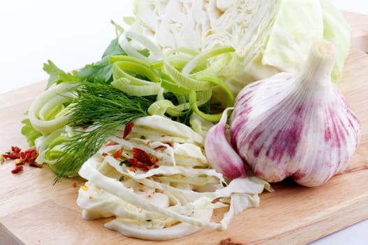 Set of cabbage and raw vegetables close up on wooden background