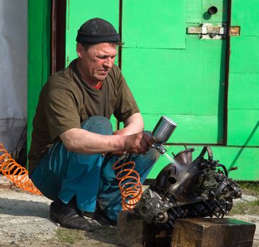 Locksmith washes the car engine before disassembly outdoors