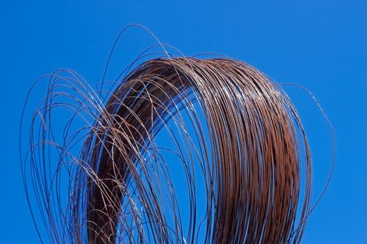 Roll of the old rusty iron wire against a blue sky