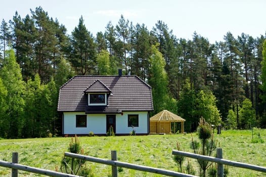 Modern apartment house on a background of a green grass and trees