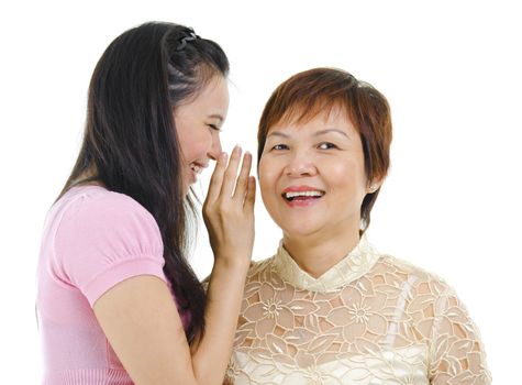Young Asian daughter talking secretly to her mum