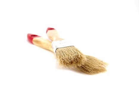 Two paint brushes over white. Shallow DOF.