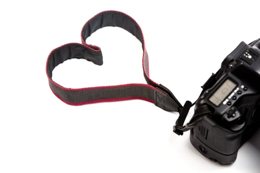 A digital camera isolated on a white background, where the strap makes a heart sign. Perfect for photography professionals and  lovers!