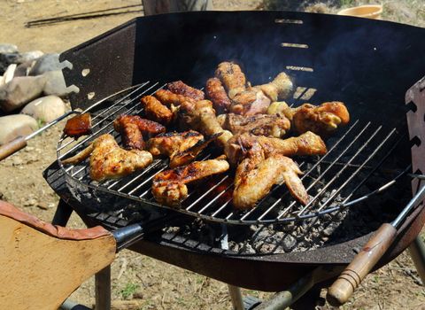chicken legs and wings roasting on grill