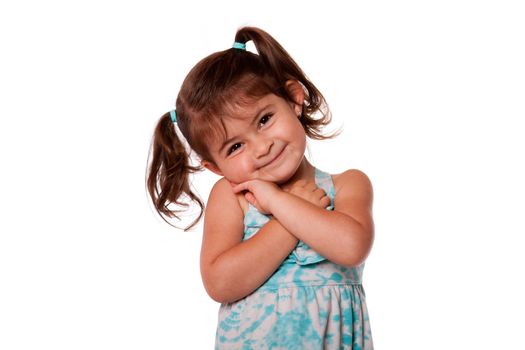 Happy smiling toddler girl with beautiful cute expression and pigtails dressed in blue, isolated.