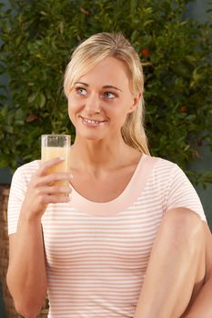 Young woman drinking a glass of healthy juice