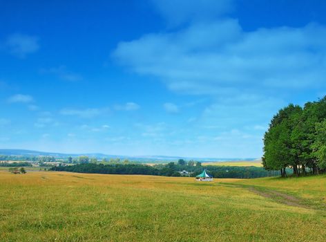 Village landscape with blue sky and clouds