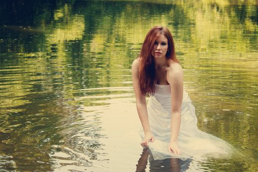 A redhead bride walking in a river