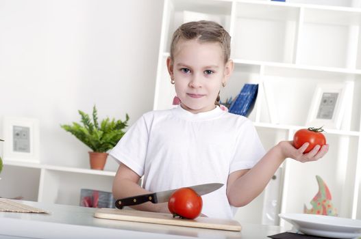 beautiful girl in the kitchen cooking vegetables