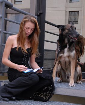 beautiful teenager reading her book with her dog
