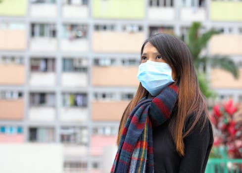 Woman wearing medical face mask in crowded city