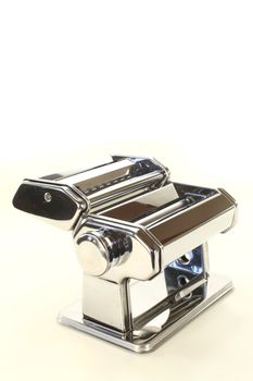 chrome Pasta machine to make pasta on a light background