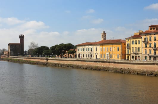 River Arno in Pisa, Italy - a panoramic view with the old citadel at the background.