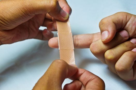 Medical plaster applied to a slightly injured child's finger for infections protection.