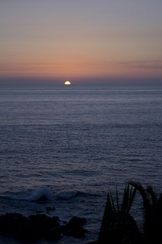 a sunset over teh ocean in a tropical location