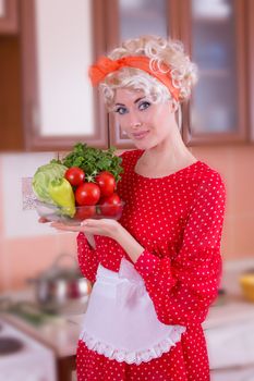 Pinup woman in red with vegetables in kitchen