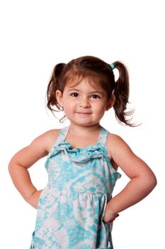Cute little young toddler girl with attitude smirk, hands on hips and pigtails in hair, isolated.