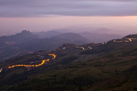 Car light in night on road in mountain.