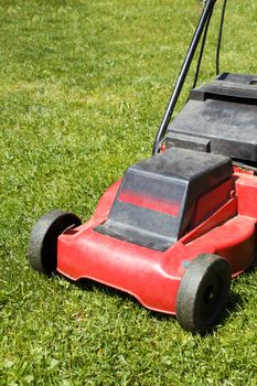 lawnmower on green grass in sunny day