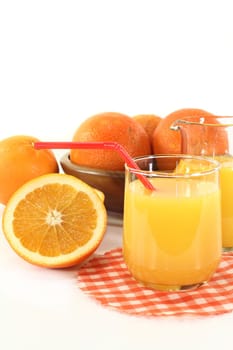 a glass of orange juice and fresh oranges