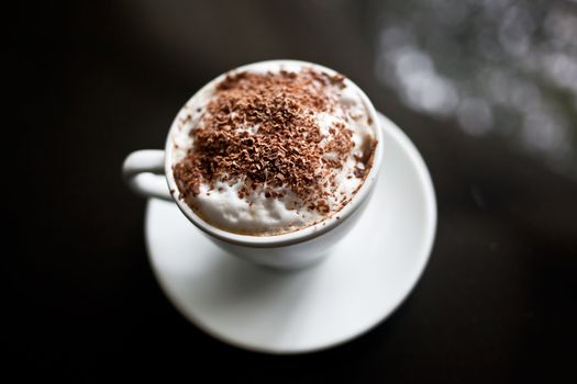 Cappuccino in white cup with chocolate sprinkles