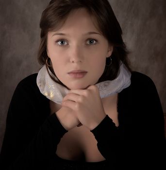 Portrait of the thoughtful girl on  dark grey background