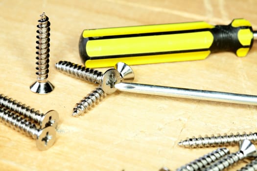 Screw-driver screws on a wooden board