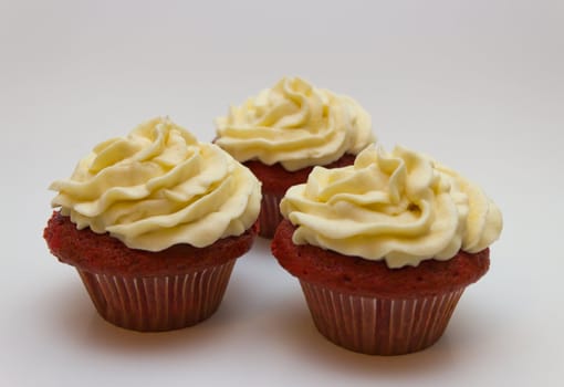 Red velvet cupcakes with buttercream icing isolated on white.