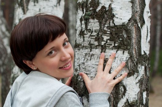 Portrait of charming girl in birch forest in spring