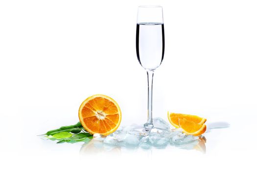 A glass of vodka with an oranges and ice
