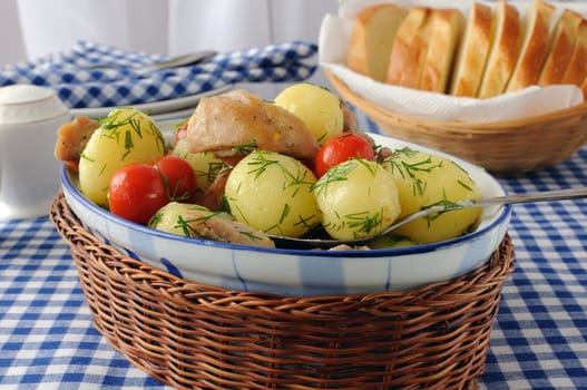 Baked potatoes with dill and chicken and tomatoes