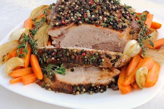 A piece of pork hams at different peppers and carrots and onions closeup