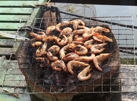 Cooking shrimp on the grill on the antique stove.