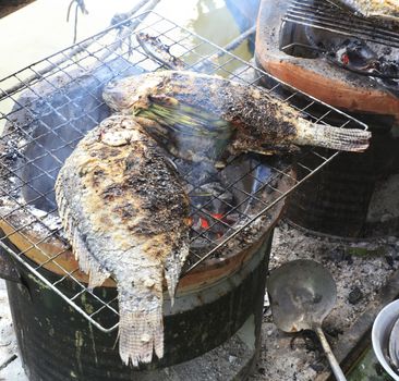 Cooking fish on the grill with antique stove.