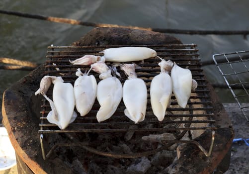 Cooking squid on the grill on the antique stove.