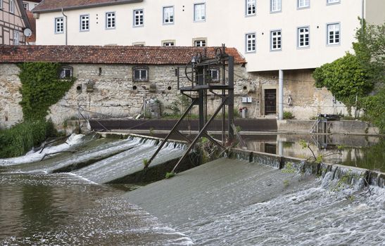 historic weir in south west germany. houses in background