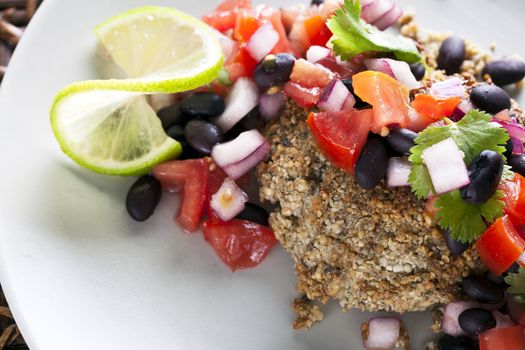 Black bean salsa on a veggie burger with lime garnish