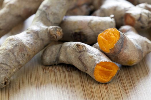 Turmeric root broken in half exposing orange root.