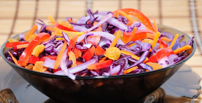 Salad of blue cabbage with carrots, peppers and raisins