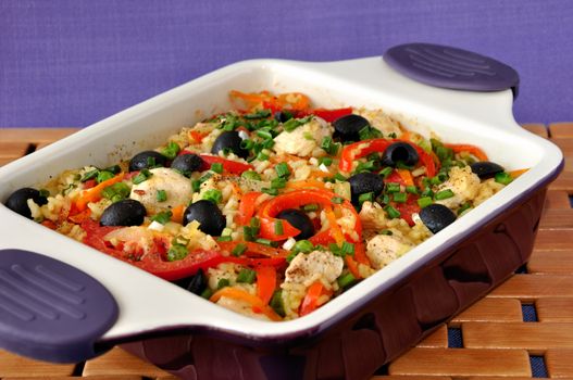 Baked rice with chicken, vegetables and olives in a saucepan