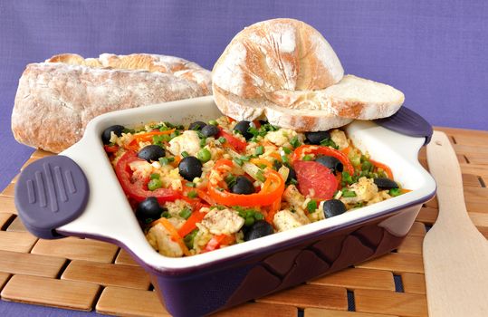 Baked rice with chicken, vegetables and olives in a saucepan
