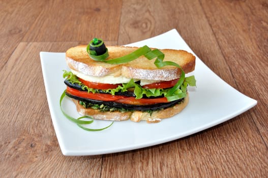 Sandwich with eggplant, tomatoes, peppers and cheese